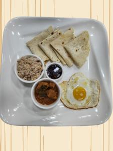 a plate of food with an egg and bread and dips at Ocean Stay & Dive in Fenfushi +20 photos