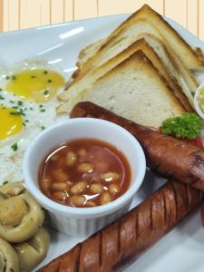 a plate of breakfast food with eggs sausage and bread at Ocean Stay & Dive in Fenfushi