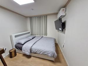 a bedroom with a bed and a television in it at Minimo Stay in Pyeongtaek