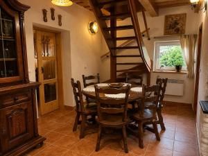 a dining room with a table and a spiral staircase at Chata Medvedík in Turík
