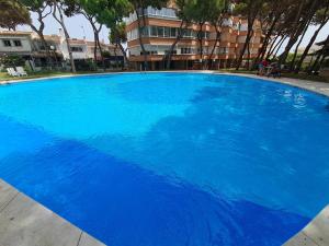 a large blue swimming pool in front of a building at Sea View Calypso Condo in Mijas