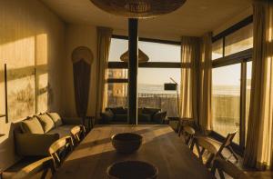 a living room with a table and a large window at Casas Punta Costanera in Pichilemu +42 photos