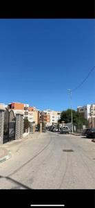 an empty street with cars parked on the side of the road at Appartement entier 1min de la plage sable d'or in Tangier