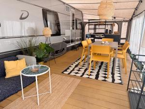 a living room with a table and chairs and a caravan at Przyczepa FOREMKA w Molo Surf in Jastarnia