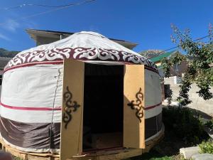a yurt with a door in a yard at Tian Shan Sky House in Naryn