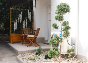 a porch with a chair and a table and trees at apartman STUDIO ELEGANCE in Bečej