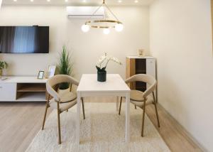 a dining room with a white table and two chairs at apartman STUDIO ELEGANCE in Bečej