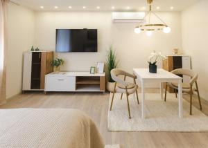 a living room with a table and a tv at apartman STUDIO ELEGANCE in Bečej