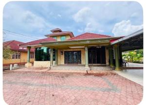 a house with a red roof and a brick driveway at Taman Darul Salam Homestay Pasir Puteh in Pasir Puteh