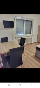 a dining room with a table and chairs and two windows at Schöne 2 zwei Zimmer Wohnung in Gleisdorf