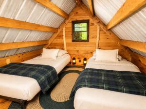 two beds in the attic of a log cabin at Off-Grid Treehouse White Mountain National Forest in North Lovell