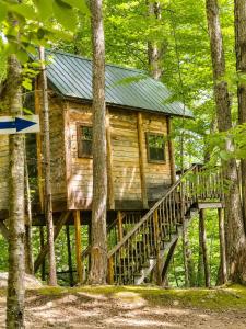 a log cabin on a bridge in the woods at Off-Grid Treehouse White Mountain National Forest in North Lovell