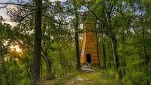 a brick tower in the middle of the woods at White Mountains A-Frame Off-Grid Stars Firepit in North Lovell +12 photos
