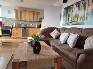 a living room with a brown couch and a table at Ski- und Wanderurlaub im Wald Ferienhaus Adlerblick in Schnett