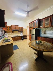 a large kitchen with a table in the middle of it at Taman Darul Salam Homestay Pasir Puteh in Pasir Puteh