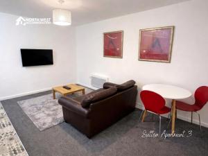 a living room with a couch and a table at Modern Serviced Apartments in St Helens with Free WiFi Ideal for Leisure or Work Stays by North West Accommodation in Saint Helens