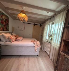 a bedroom with a bed and a chandelier at Bed & Breakfast Betuws Genieten in Tiel