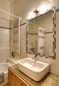a bathroom with a sink and a tub and a mirror at Rodoula apts By Comfortbnb in Roússa Ekklisía +44 photos