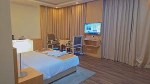 a hotel room with a bed and a television at Mirador Hotel in Manama