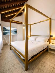 a bedroom with a four poster bed with white sheets at Baco Da Seta Residence con Piscina - Venezia Mestre in Mestre +30 photos