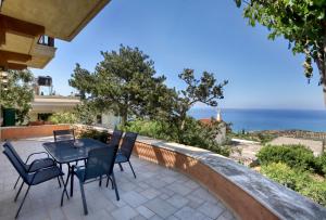 a patio with a table and chairs overlooking the ocean at Rodoula apts By Comfortbnb in Roússa Ekklisía