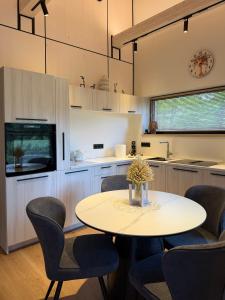 a kitchen with a round table and chairs at Beiri in Dravnieki