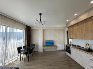 a kitchen with a table and chairs and a television at GM Apartment in Tbilisi City +13 photos