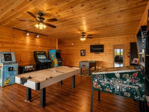 a room with a ping pong table and arcade games at Gatlinburg Mansion Cabin in Pittman Center
