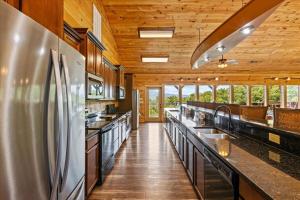 a large kitchen with stainless steel appliances and wooden ceilings at Gatlinburg Mansion Cabin in Pittman Center +54 photos