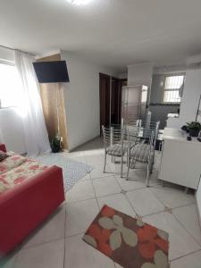 a living room with a table and chairs and a kitchen at Apartamento térreo bem equipado, fácil acesso in Canoas