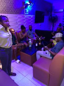 a group of people sitting on a couch in a room at Diamond Groove Hotel & Suites in Sangotedo