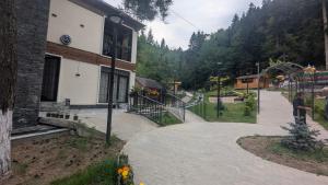 a man standing outside of a building with a playground at hotel G&G in Tsaghveri