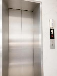 a metal elevator with a phone on a wall at Khách sạn Đạt Tiến Quân in Ấp Bình Hưng