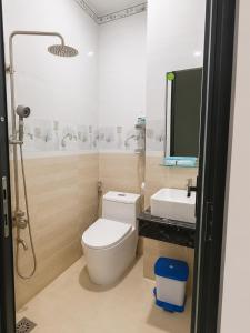a bathroom with a toilet and a sink at Khách sạn Đạt Tiến Quân in Ấp Bình Hưng +4 photos