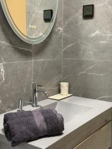 a bathroom sink with a purple towel and a mirror at Beiri in Dravnieki