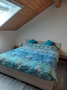 ein Bett mit einer blauen Bettdecke in einem Schlafzimmer in der Unterkunft Baloe in Manderfeld