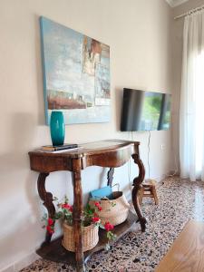 a room with a wooden table with a television on it at Parga Heritage in Parga