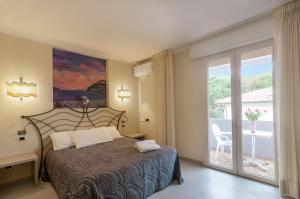 a bedroom with a bed with a view of a balcony at Hotel Barcarola 2 in Marina di Campo