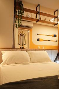 a bedroom with a large white bed with shelves at Tiwa Studio Requinte Amazônico Adrianópolis in Manaus +115 photos