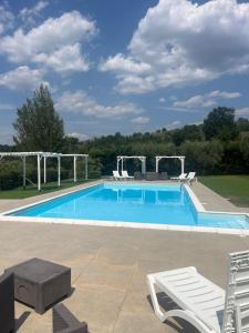 a large swimming pool with two chairs and a table at Casa Vacanze Masseria Tidei in Sant'Agata de' Goti