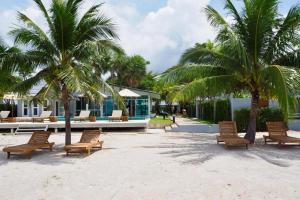 a group of chairs and palm trees on a beach at Bann Sunset Cove Krabi I A Hidden Luxury Escape on Had Yao Beach in Krabi