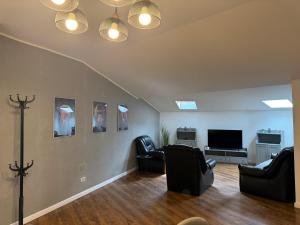 a living room with chairs and a flat screen tv at Dare apartments 1 in Giurgiu
