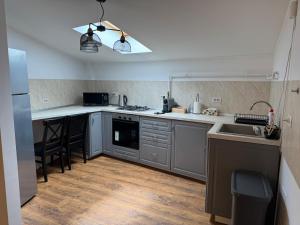 a kitchen with stainless steel appliances and a wooden floor at Dare apartments 1 in Giurgiu +16 photos