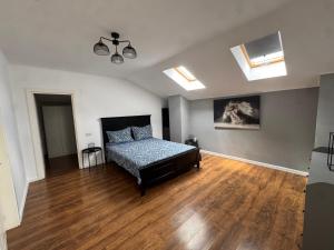 a bedroom with a bed and a wooden floor at Dare apartments 1 in Giurgiu