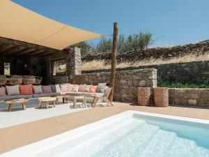 a patio with a pool and a table and chairs at Villa Yasemin - Mykonos Paradise - Views - Pool - Large Garden in Kalafatis