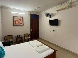 a bedroom with a bed and a tv on the wall at Khách sạn Hùng Thắng in Vĩnh Lộc