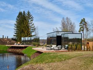 a glass house on a dock next to a river at CR x Rae Golf in Suuresta