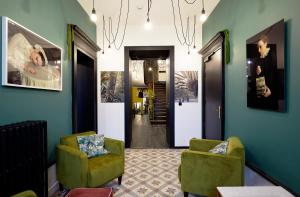 a hallway with two green chairs and a hallway with a hallway at Le Boutik Hotel in Annecy