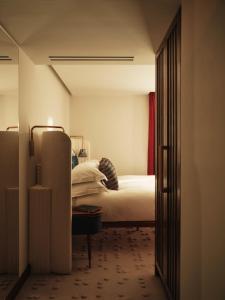 a bedroom with a bed and a door leading into a room at The Shepherd Mayfair in London