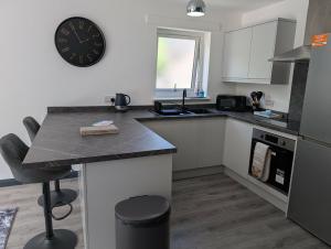 a kitchen with a counter and a clock on the wall at Wee Catriona in Brodick